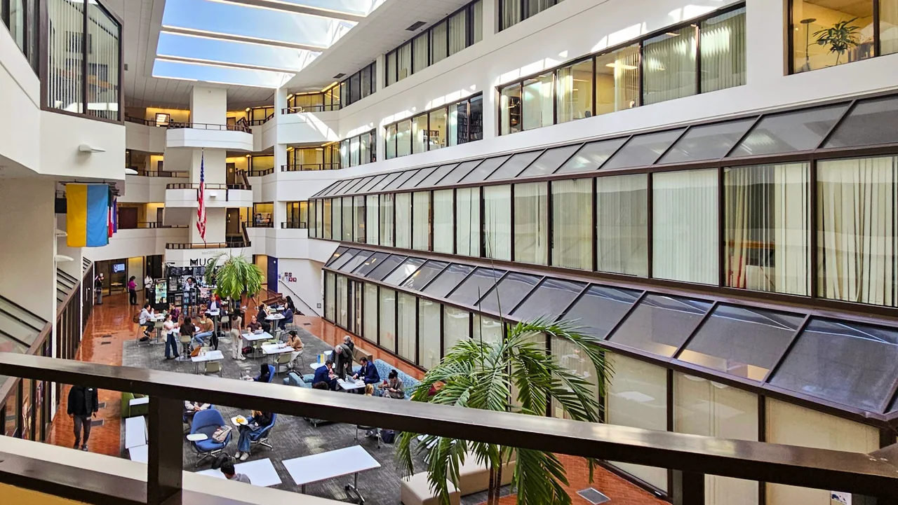 Existing Georgetown atrium with white balconies and brick floor.