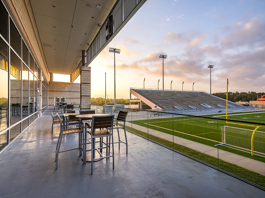 An elevated terrace overlooks the stadium at sunset.