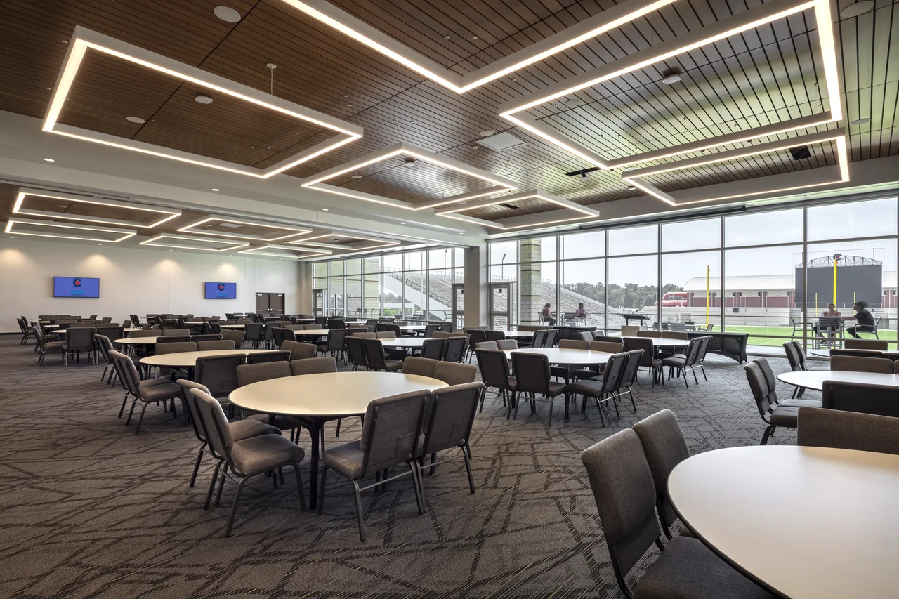 Completed conference room with flexible tables and expansive windows facing the stadium.
