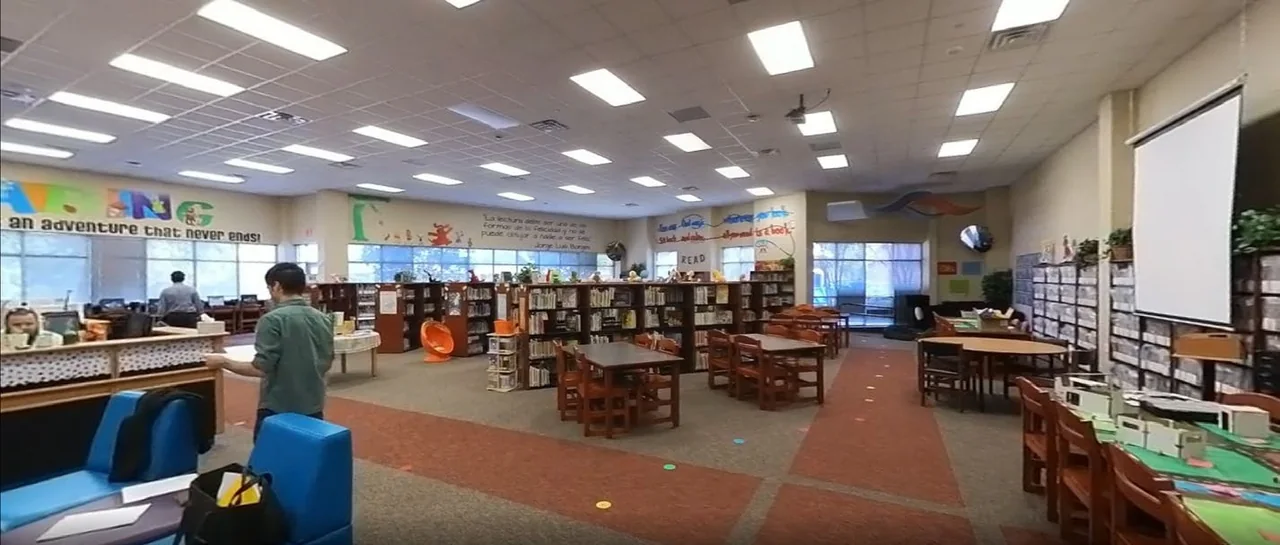 The original library with freestanding shelves and a flat ceiling.