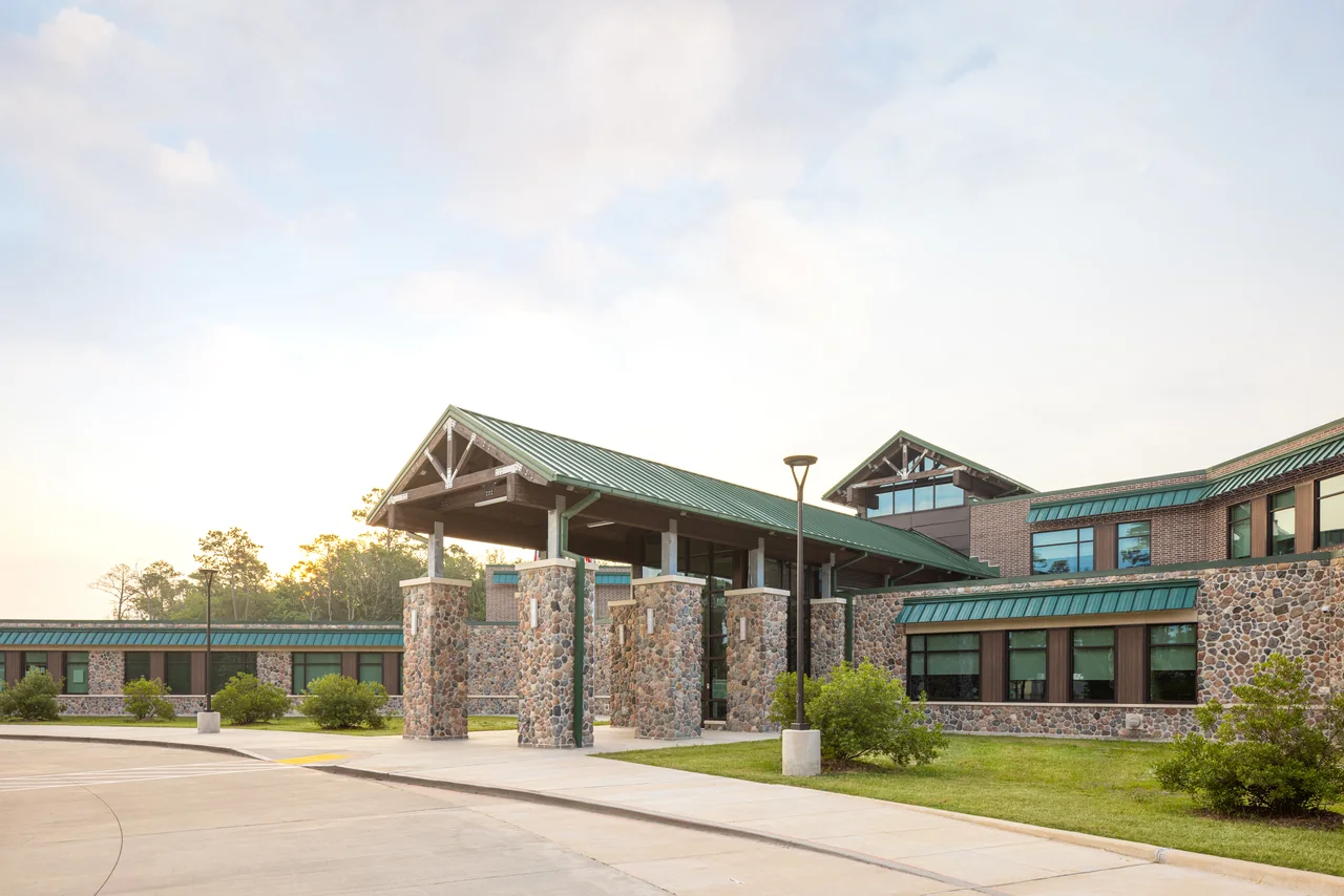 Stone and timber entrance framed by trees at North Bend Elementary.