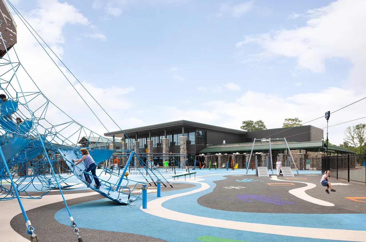A blue climbing structure stands beside the school courtyard.