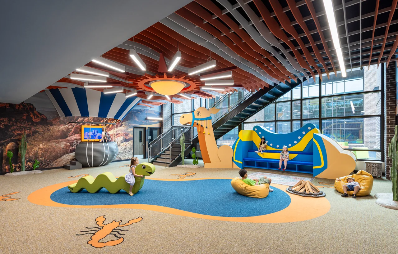 Savanna collaboration space with a giraffe structure, slide and sculptural ceiling.