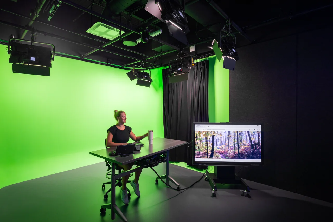 Virtual teaching studio with green-screen walls, cameras and lighting.