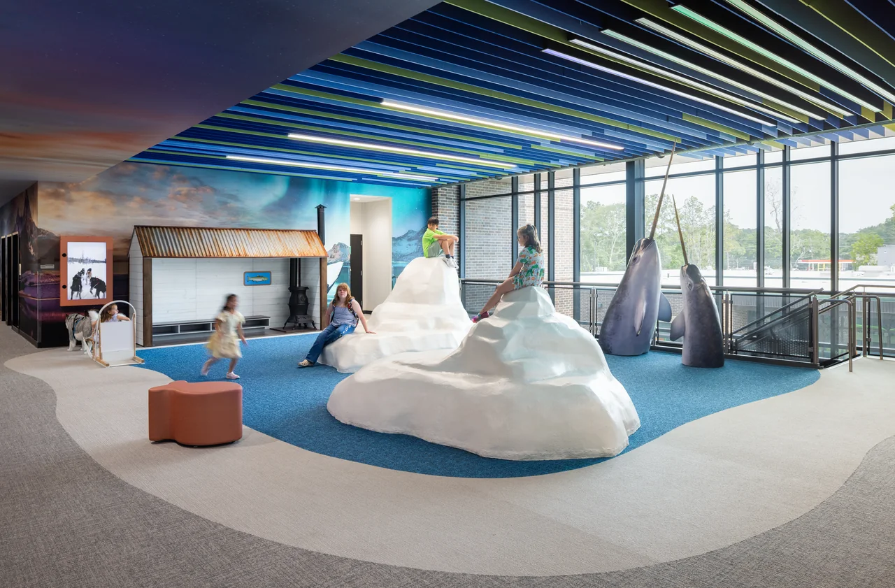 White sculptural seating fills a blue and gray learning space.