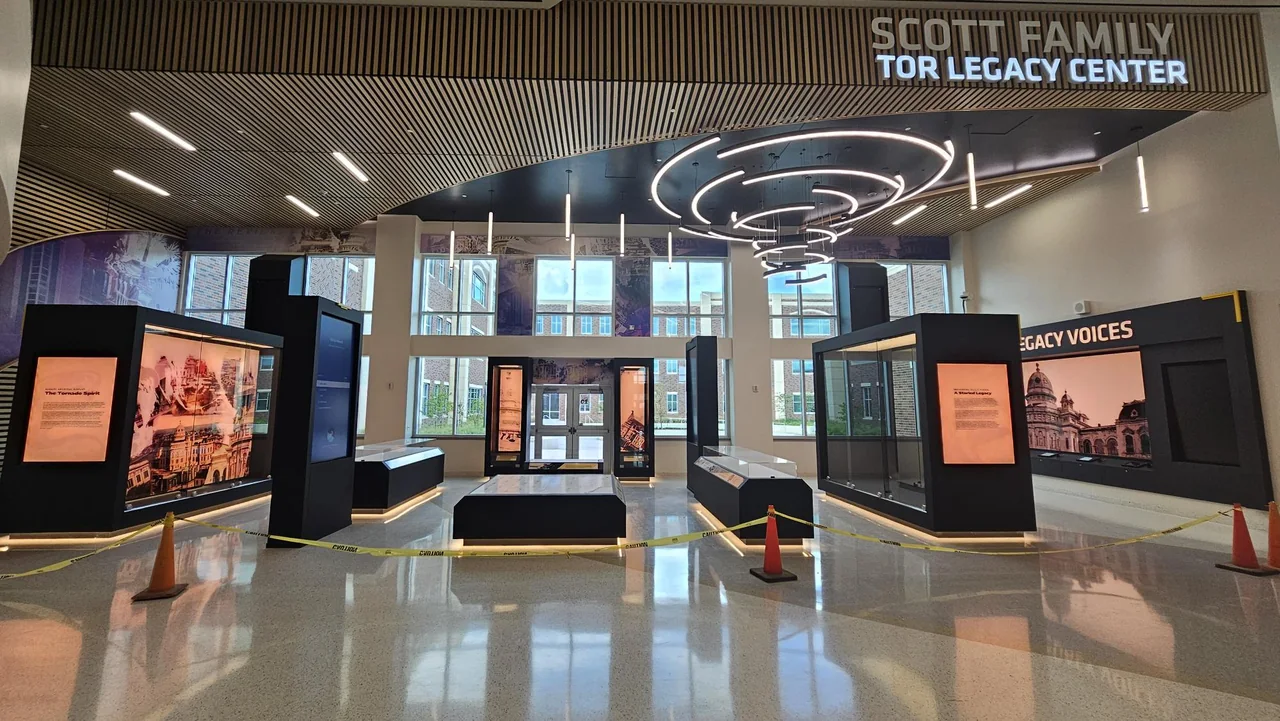 Illuminated exhibit towers stand beneath circular lights at the Tor Legacy Center.